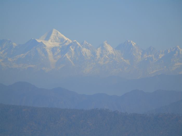 The Panchachuli range rising above layered blue ridges of the Kumaon Himalaya